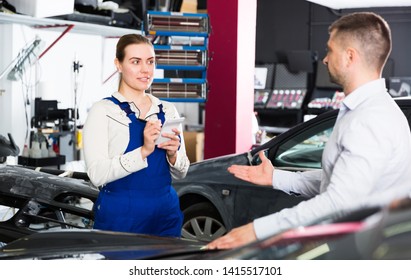 Professional female mechanic discussing with male client and recording list of works on car repair in auto repair shop 
 - Powered by Shutterstock