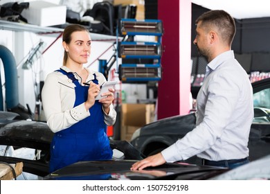 Professional female mechanic discussing with male client and recording list of works on car repair in auto repair shop 
 - Powered by Shutterstock