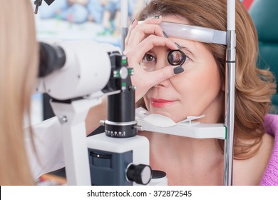 Professional female ophthalmologist is checking human eyes