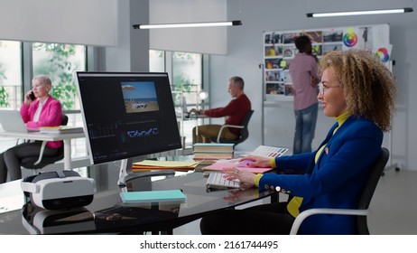 Professional Female Photographer Works In Photo Editing App. Editor Retouching Video On Computer In Modern Creative Office