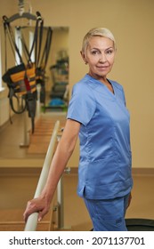 Professional Female Physiotherapist Standing In Rehabilitation Center