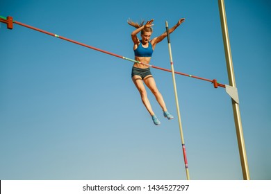 Professional female pole vaulter training at the stadium in sunny day. Fit female model practicing in high jumps outdoors. Concept of sport, activity, healthy lifestyle, action, movement, motion. - Powered by Shutterstock