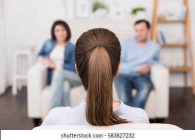Professional female psychologist sitting opposite her patients