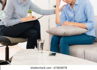 professional female psychologist working with teenage girl in office and talking with her assistant to therapy depression sickness.
