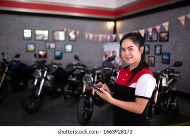 Professional Female Salesman At A Motorcycle Dealer In A Sales Showroom In Asia.