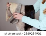 Professional female skinner, furrier working with mink fur skin at atelier, workshop.