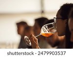 Professional Female Sommelier -Representative of Alcohol Company Tasting Beer from Special Degustation Glass During Lecture about Basic of Brewing and Craft Beer.