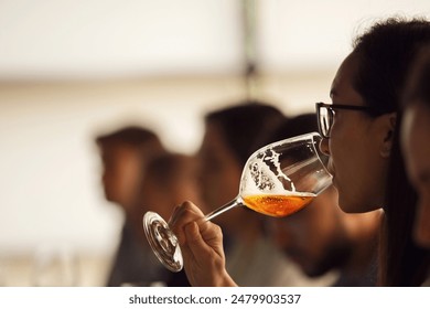 Professional Female Sommelier -Representative of Alcohol Company Tasting Beer from Special Degustation Glass During Lecture about Basic of Brewing and Craft Beer. - Powered by Shutterstock