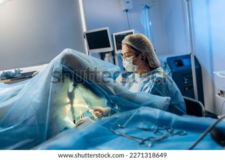 Professional female surgeon proctologist performing operation using special medical devices in the operating room in hospital. Urgent surgical concept