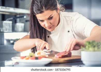 Professional female sushi chef cuts tuna fish in a pro kitchen. - Powered by Shutterstock