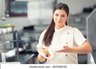 Professional Female Sushi Chef Presents A Dish In A Restaurant Kitchen.