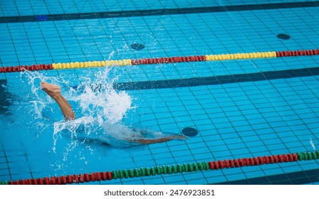 Professional female swimmer preparing and jumping off the starting block into the pool. Competitive swimmers workout concept. - Powered by Shutterstock