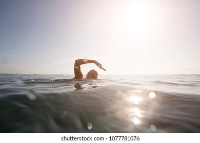 Professional Female Swimmer Swim In The Ocean On The Sunrise