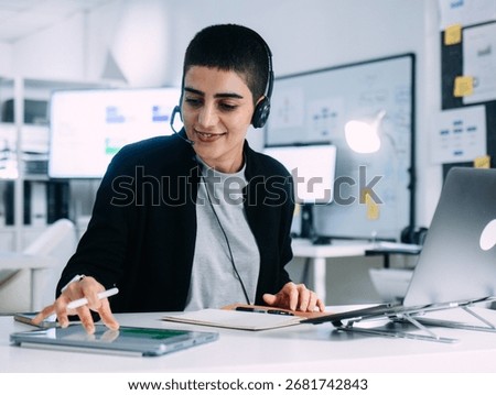 Professional Female Technical Support Operator with headset talking with client while using digital tablet reading customer data information for CRM, Help, Advice working in call center office.