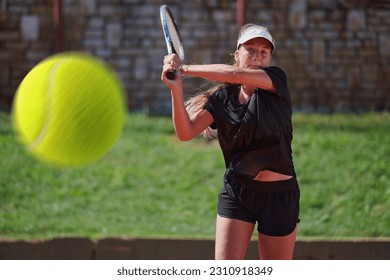 A professional female tennis player serves the tennis ball on the court with precision and power - Powered by Shutterstock