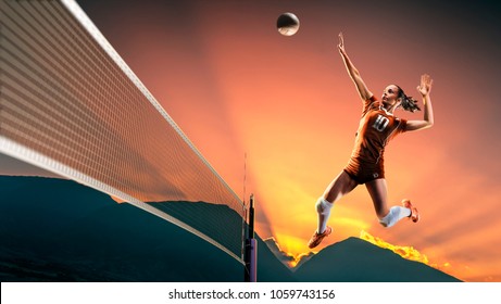 Professional female volleyball player in action at the sunset