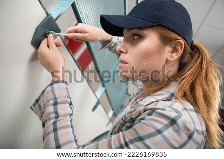 professional female worker using spanner to undo nut