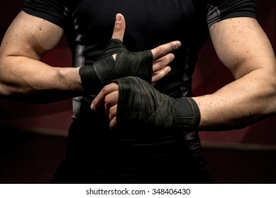 professional fighter preparing for training, wrapping his hands and wrists - Powered by Shutterstock