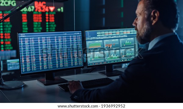 Professional Financial Data Analysts Working\
in a Modern Monitoring Office with Live Analytics Feed on a Big\
Digital Screen. Monitoring Room with Finance Specialists Sit in\
Front of\
Computers.