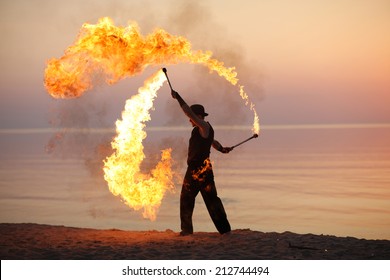 Professional fire juggler performing on the beach - Powered by Shutterstock