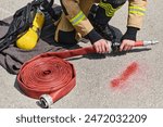 Professional Firefighter Cleaning Up Fire Hose After Extinguishing Blaze