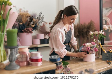 Professional florist young woman is doing bouquets at flower shop - Powered by Shutterstock