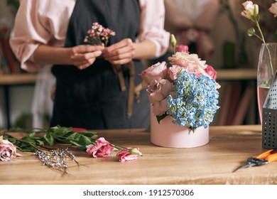 Professional florist young woman is doing bouquets at flower shop - Powered by Shutterstock