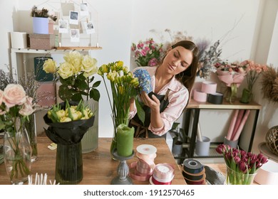 Professional florist young woman is doing bouquets at flower shop - Powered by Shutterstock