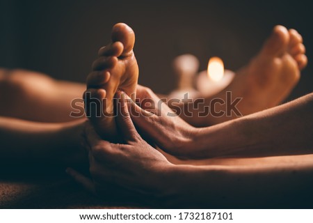 Professional foot massage close up. Authentic shot of luxury spa treatment. Charming light. Shallow depth of field. Stylized and colored.
