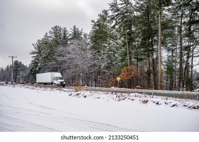 Professional Freight Day Cab Industrial Big Rig Semi Truck Transporting Cargo In Dry Van Semi Trailer Running On The Local Road Along The Forest With Snow And Ice At Winter Season In New Hampshire