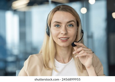 A professional, friendly woman wearing a headset talks directly to the camera in a bright, modern office environment, indicating customer service or remote communication. - Powered by Shutterstock