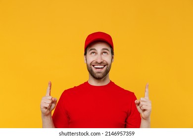 Professional Fun Delivery Guy Employee Man In Red Cap T-shirt Uniform Workwear Work As Dealer Courier Point Index Finger Overhead On Workspace Area Isolated On Plain Yellow Background Service Concept