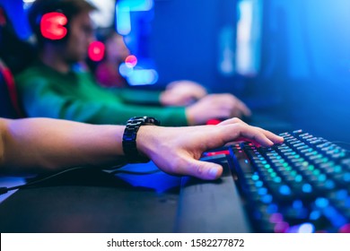 Professional gamer greeting and support team fists hands online game in neon color blur background. Soft focus, back view. - Shutterstock ID 1582277872