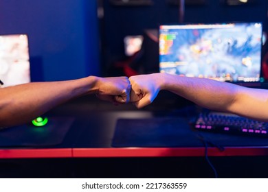 Professional Gamer Greeting And Support Team Fists Hands Online Game In Neon Color Blur Background. Soft Focus, Back View.