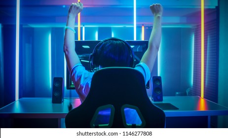 Professional Gamer Playing and Winning in First-Person Shooter Online Video Game on His Personal Computer. Footage Fade out into Bokeh. Room Lit by Neon Lights in Retro Arcade Style.Cyber Championship