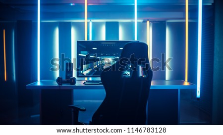 Professional Gamers Room With Ultra Powerful Personal Computer. Paused First-Person Shooter Game on Screen. Room Lit by Neon Lights in Retro Arcade Style. Cyber Sport Championship.