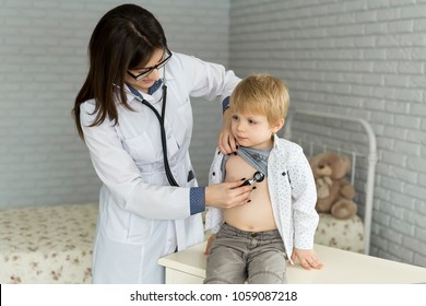 Professional General Medical Pediatrician Doctor In White Uniform Gown Listen Lung And Heart Sound Of Child Patient With Stethoscope.