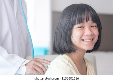 Professional General Medical Pediatrician Doctor In White Uniform Gown Listen Lung And Heart Sound Of Asia Child Patient With Stethoscope: Physician Check Up Asian Kid Female After Consult In Hospital