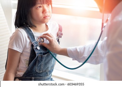 Professional General Medical Pediatrician Doctor In White Uniform Gown Listen Lung And Heart Sound Of Asia Child Patient With Stethoscope: Physician Check Up Asian Kid Female After Consult In Hospital