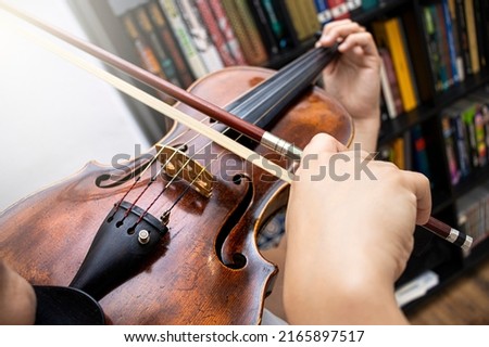 Professional girl violinist playing an antique virtuous violin