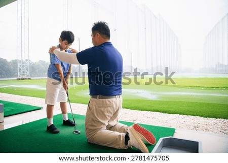 Professional golf instructor demonstrates the grip technique to young student. Focus on proper hand placement and grip helps build strong foundation for future golf success at driving range facility.