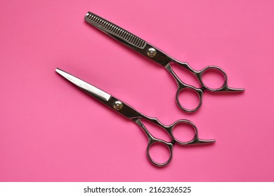 Professional Hair Dresser Tools On Pink Background With Copy Space. Hair Stylist Equipment Set. Scissors Flat Lay Top View.