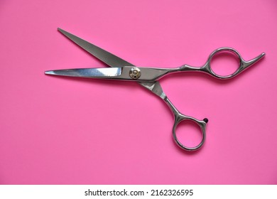 Professional Hair Dresser Tools On Pink Background With Copy Space. Hair Stylist Equipment Set. Scissors Flat Lay Top View.