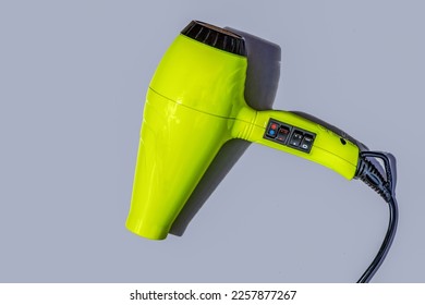 Professional hair dryer in bright green color on a gray background close-up. - Shutterstock ID 2257877267