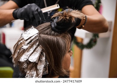 Professional hair treatment and applying highlights to a woman's hair in a modern beauty salon. High-quality hairdressing services - Powered by Shutterstock