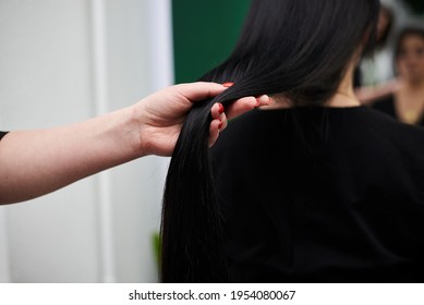 Professional Hairdresser Making Hairstyling For Female Client In Front Of Mirror. Close-up Picture Of Work Process In Barber Shop. Young Brunette Woman Getting Ready For Party