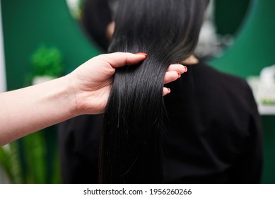 Professional Hairdresser Making Hairstyling For Female Client In Front Of Mirror. Close-up Picture Of Work Process In Barber Shop. Young Brunette Woman Getting Ready For Party