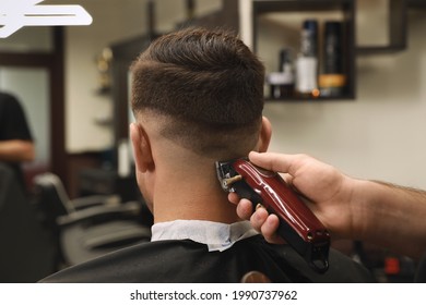 Professional hairdresser making stylish haircut in salon, back view - Powered by Shutterstock