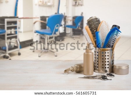 Professional hairdresser tools on table over defocused salon interior background.