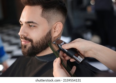 Professional hairdresser working with client in barbershop - Powered by Shutterstock